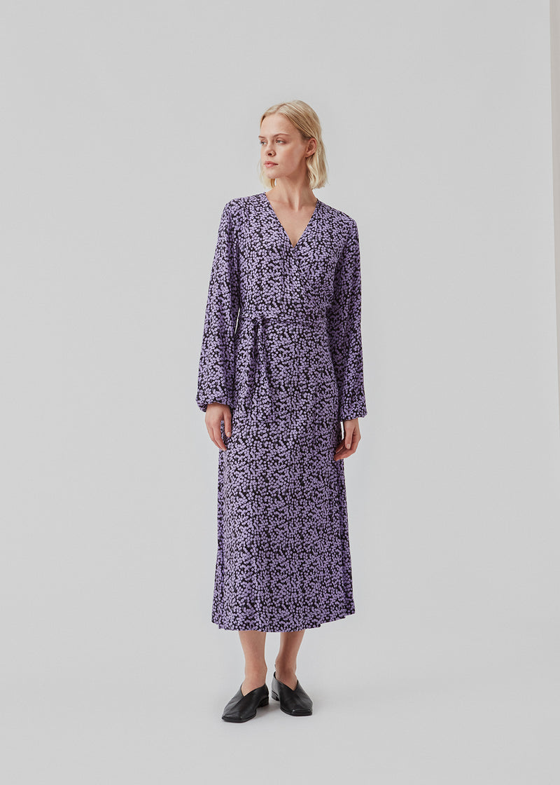 Long dress with wrap effekt and tiebelt at the waist. ChesliMD print wrap dress has long puff sleeves and v-neckline.