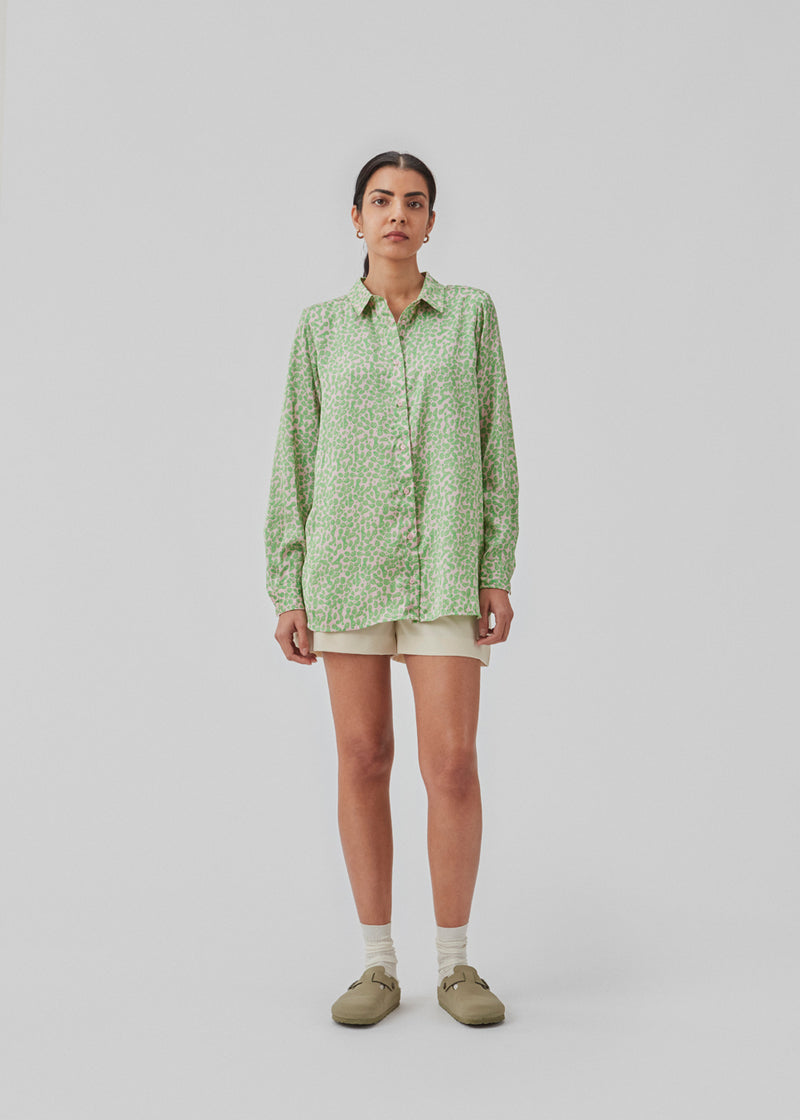 Satin shirt with relaxed fit and long sleeves, collar, and buttons in front. ClarkeMD print shirt is cut from recycled polyester with smiley print.