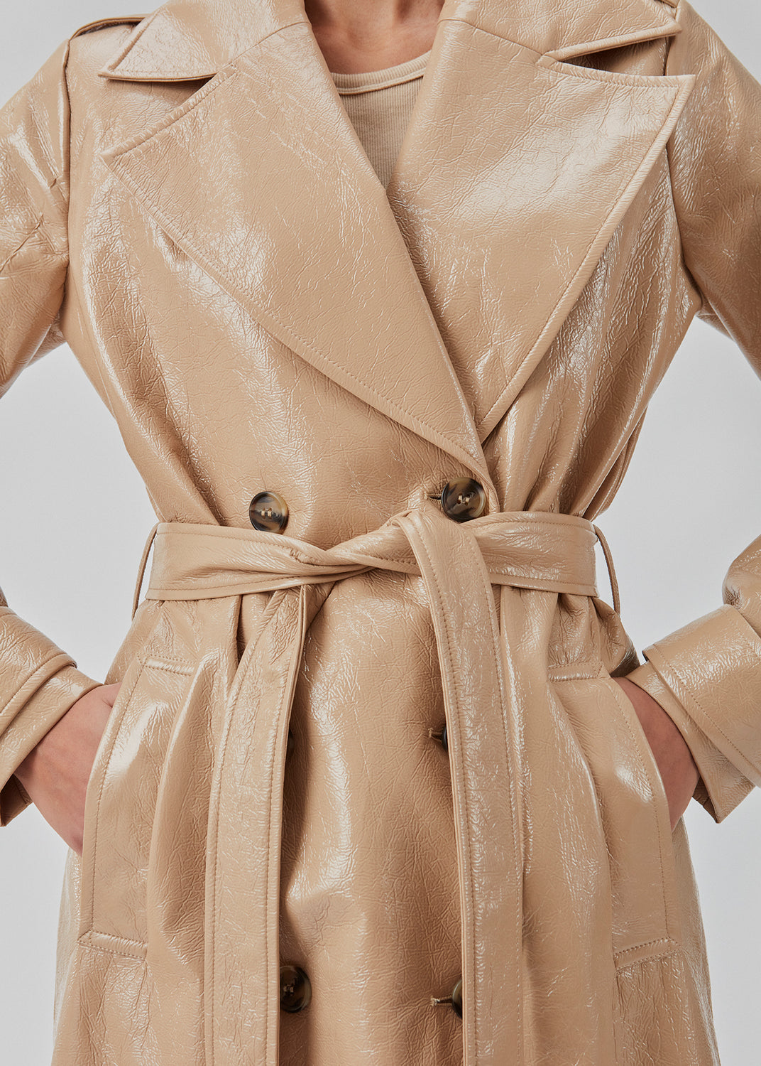 Coat in a shiny material. CollinsMD coat has a classic trenchcoat look with wide collar and lapel, button closure, and belt at the waist.