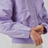 Short, padded bomber jacket in purple. ColtonMD jacket is designed with a collar, zipper in front, and pockets with push buttons. Ribbing at the hem.