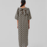 Long dress with a wide skirt and voluminous puff sleeves. CoraMD print dress has a round neck with a cut out and bow in the back. Made from organic cotton.  The model is 174 cm and wears a size S/36.