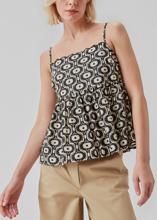 Top with thin adjustable straps, wavy trimmings, and a peplum effect. CoraMD print top is cut from printed organic cotton. The model is 174 cm and wears a size S/36.