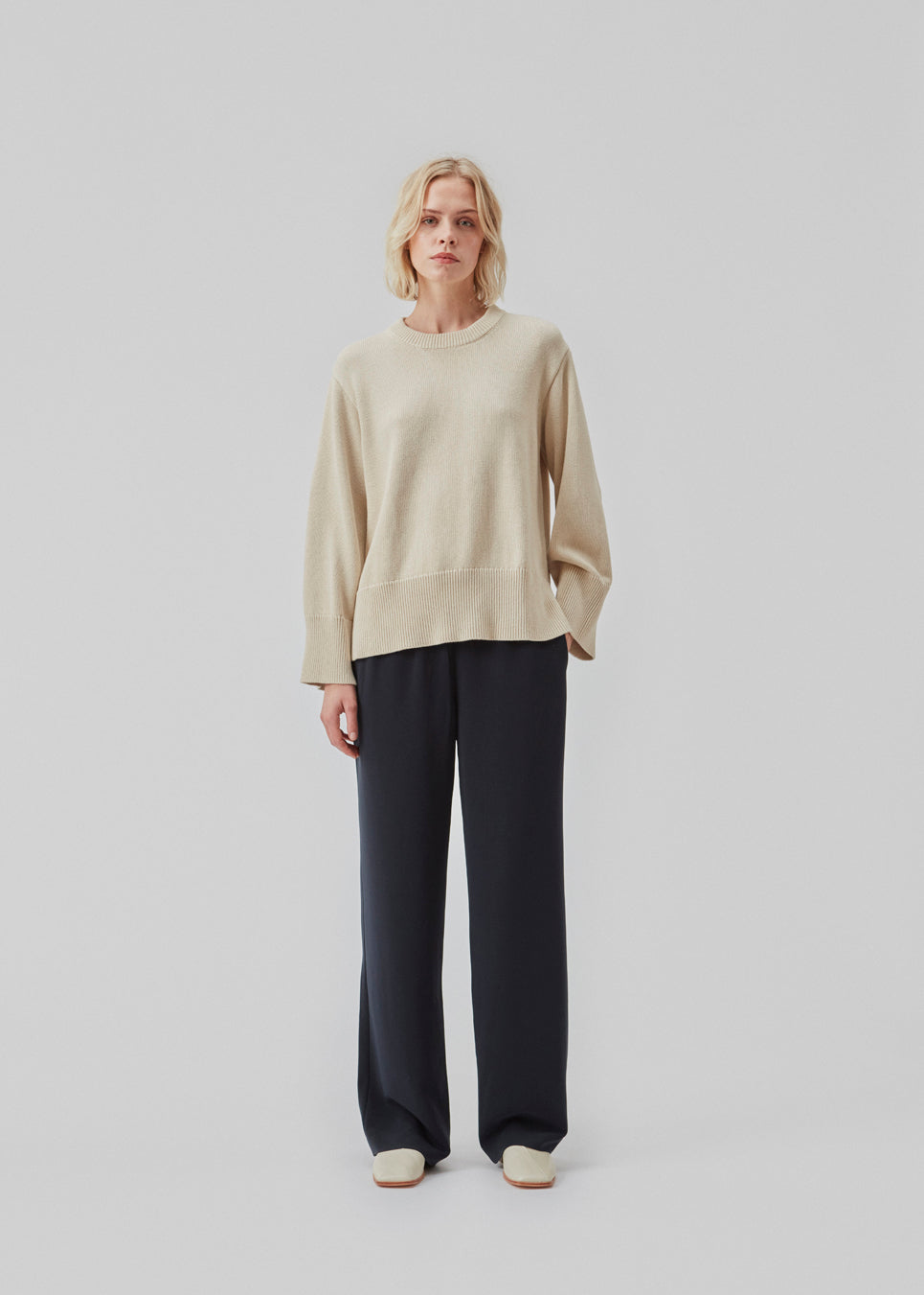 Fine-knitted oversize jumper in beige knitted from cotton. CorbinMD o-neck has ribbed round neckline, long wide sleeves, and wide ribbing at cuffs and hem.