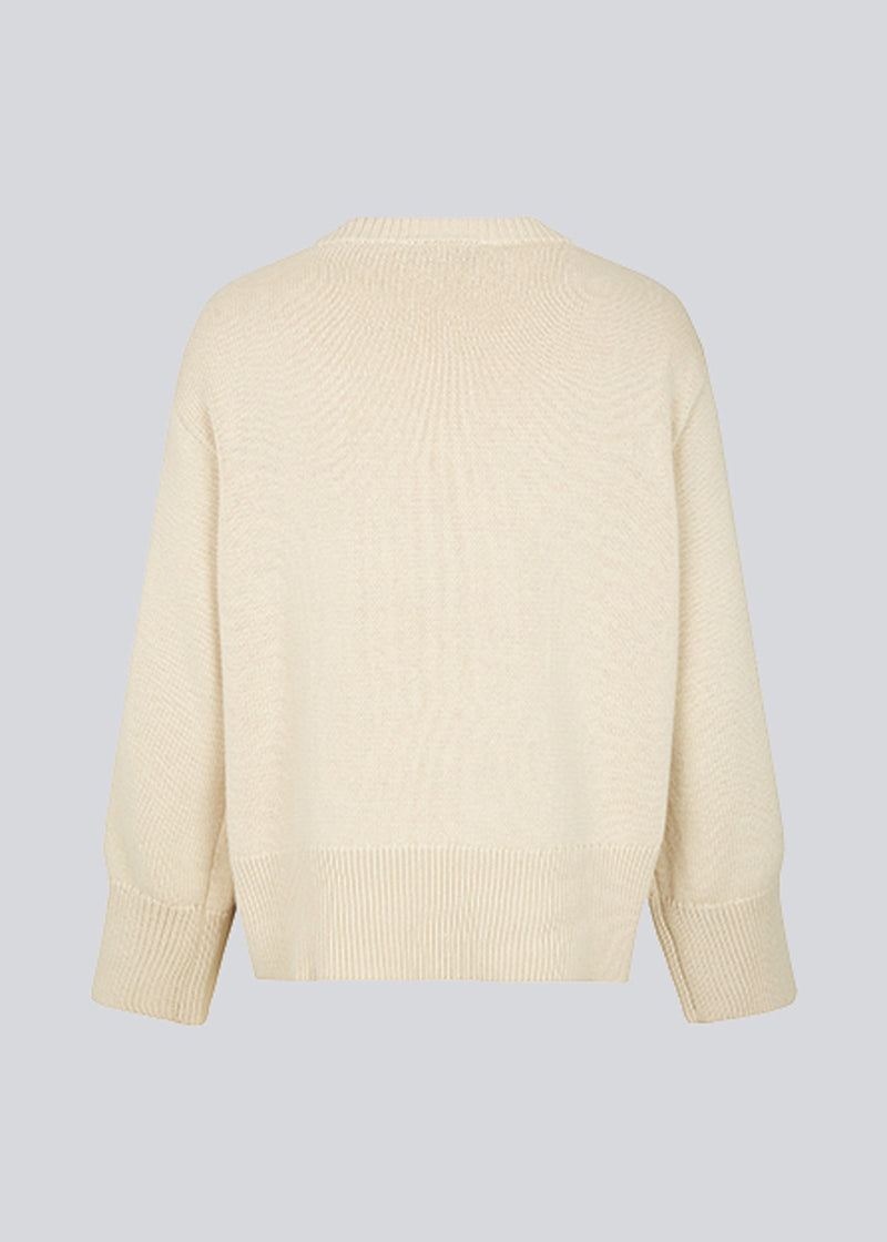 Fine-knitted oversize jumper in beige knitted from cotton. CorbinMD o-neck has ribbed round neckline, long wide sleeves, and wide ribbing at cuffs and hem.