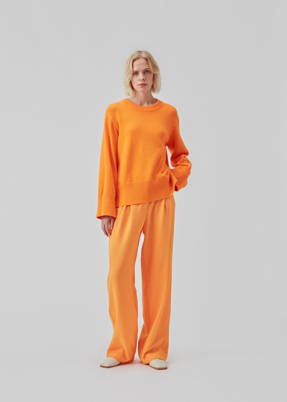 Fine-knitted oversize jumper orange knitted from cotton. CorbinMD o-neck has ribbed round neckline, long wide sleeves, and wide ribbing at cuffs and hem.