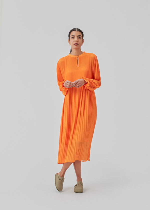 Pleated dress in recycled polyester. CruzMD dress has 3/4 sleeves with elastic, keyhole detail in front, and an airy skirt.  The model is 177 cm and wears a size S/36.