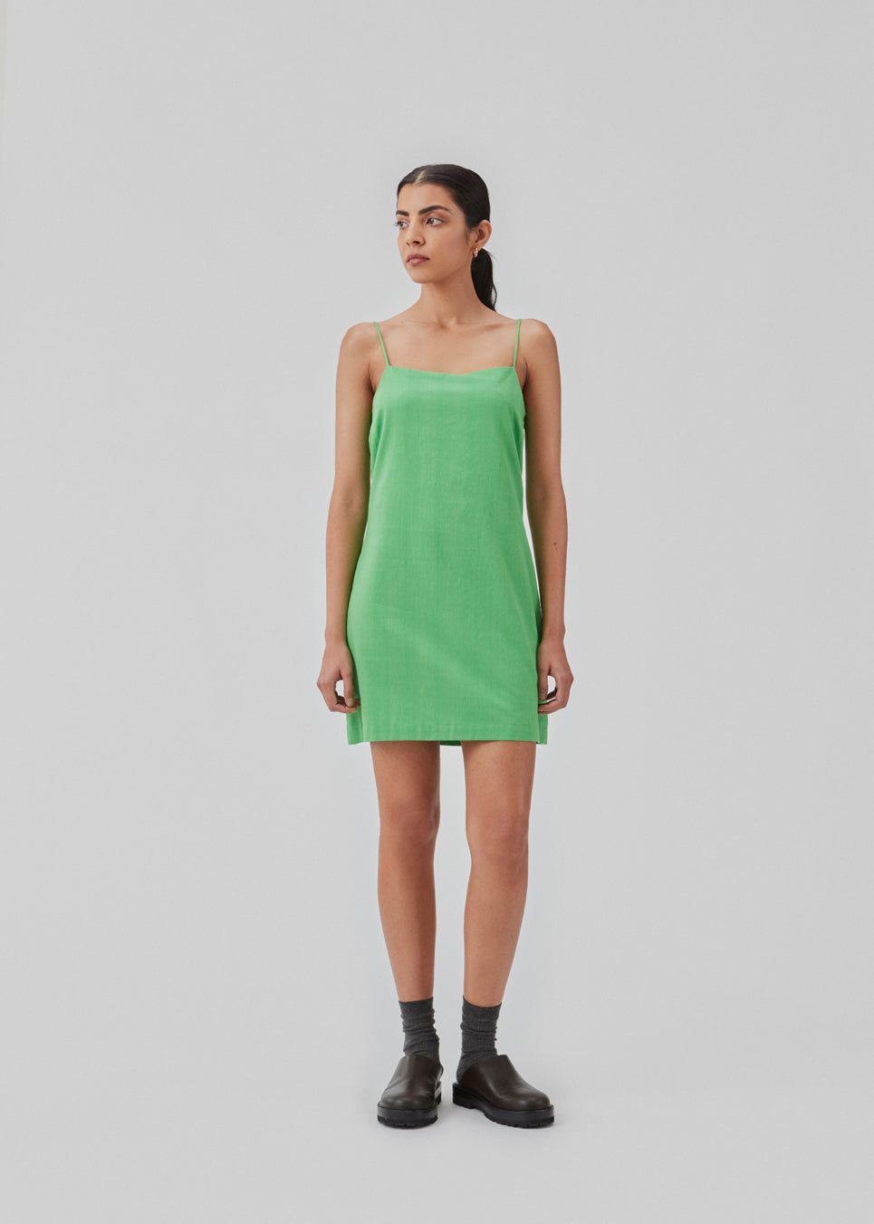 Short dress in green with a clean look in woven cotton. CydneyMD dress is slightly tailored, has adjustable straps, and a hidden zipper on one side. The model is 174 cm and wears a size S/36.