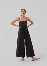 Jumpsuit with spaghetti straps in woven cotton. CydneyMD jumpsuit is designed with ankle-length wide legs and a tight-fitting top. The model is 174 cm and wears a size S/36.