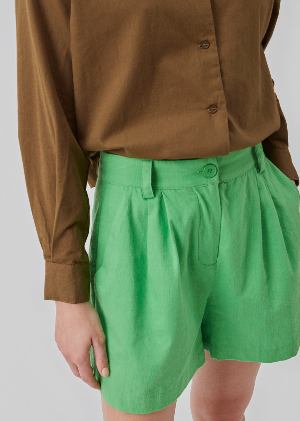 Cotton shorts in green with wide legs. CydneyMD shorts have a tailormade look with pleats in front and paspoil pockets in back. The model is 174 cm and wears a size S/36.