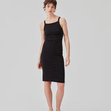Tight fitted basic black dress in organic cotton jersey. DaeMD dress is sleeveless with a high and straight neckline. The dress cuts below the knees. The model is 177 cm and wears a size S/36.