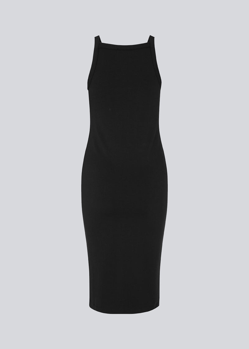 Tight fitted basic black dress in organic cotton jersey. DaeMD dress is sleeveless with a high and straight neckline. The dress cuts below the knees. The model is 177 cm and wears a size S/36.