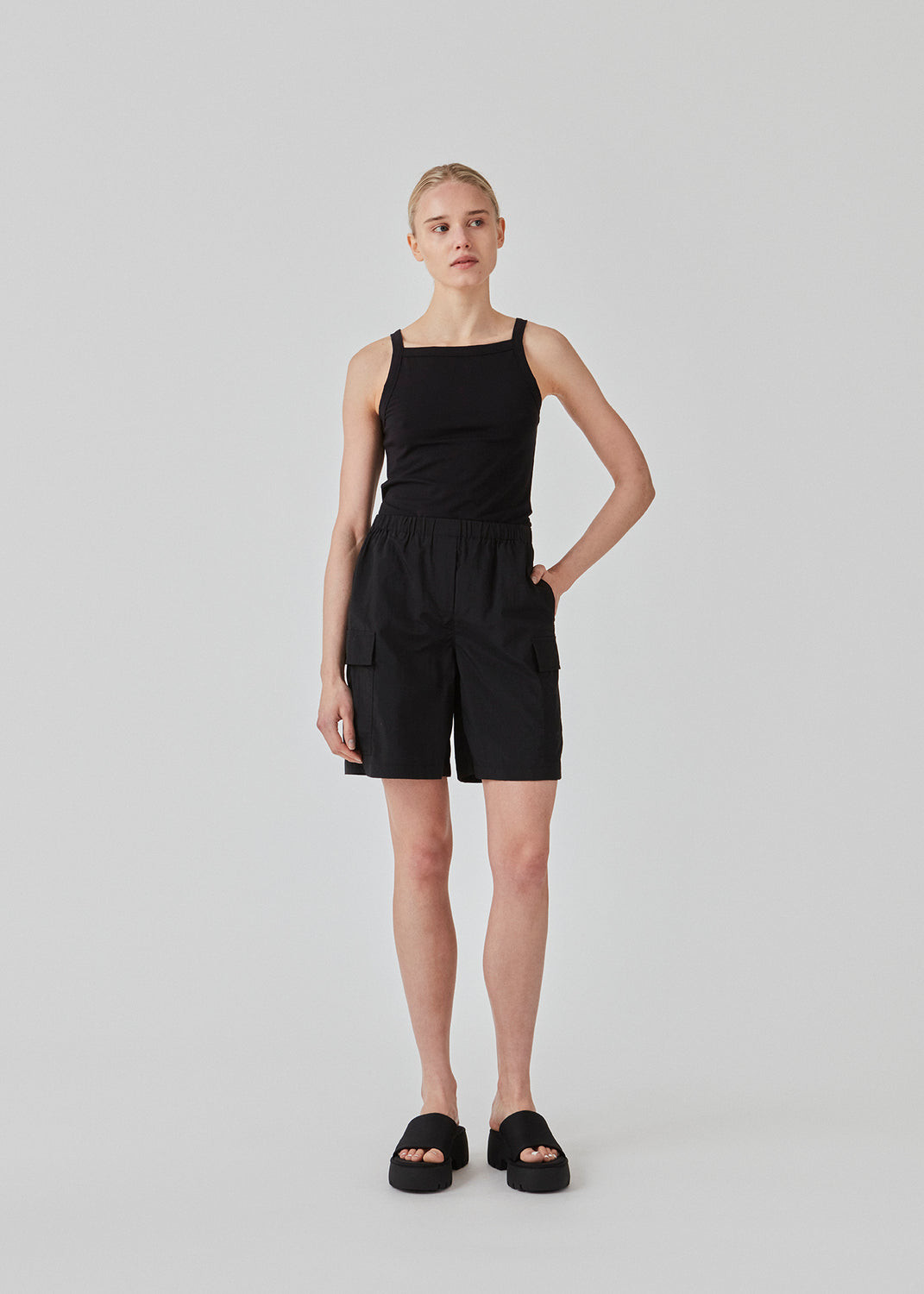 Tight fit basic black top with a high and straight neckline. DaeMD top is made from a rib-knitted organic cotton. The model is 177 cm and wears a size S/36.