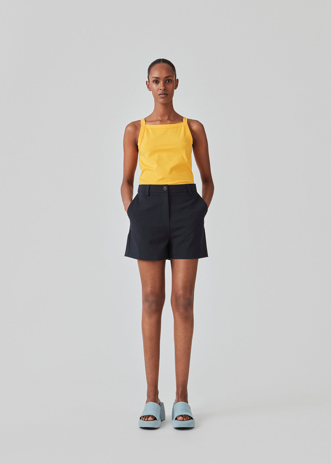 Tight fit basic yellow top with a high and straight neckline. DaeMD top is made from a rib-knitted organic cotton. The model is 177 cm and wears a size S/36.