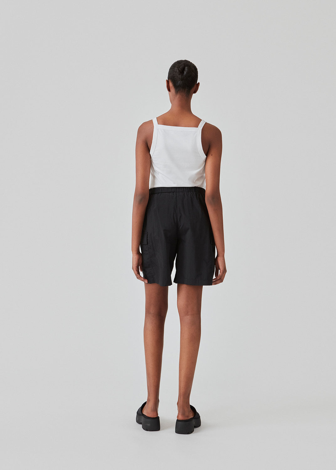 Tight fit basic white top with a high and straight neckline. DaeMD top is made from a rib-knitted organic cotton. The model is 177 cm and wears a size S/36.