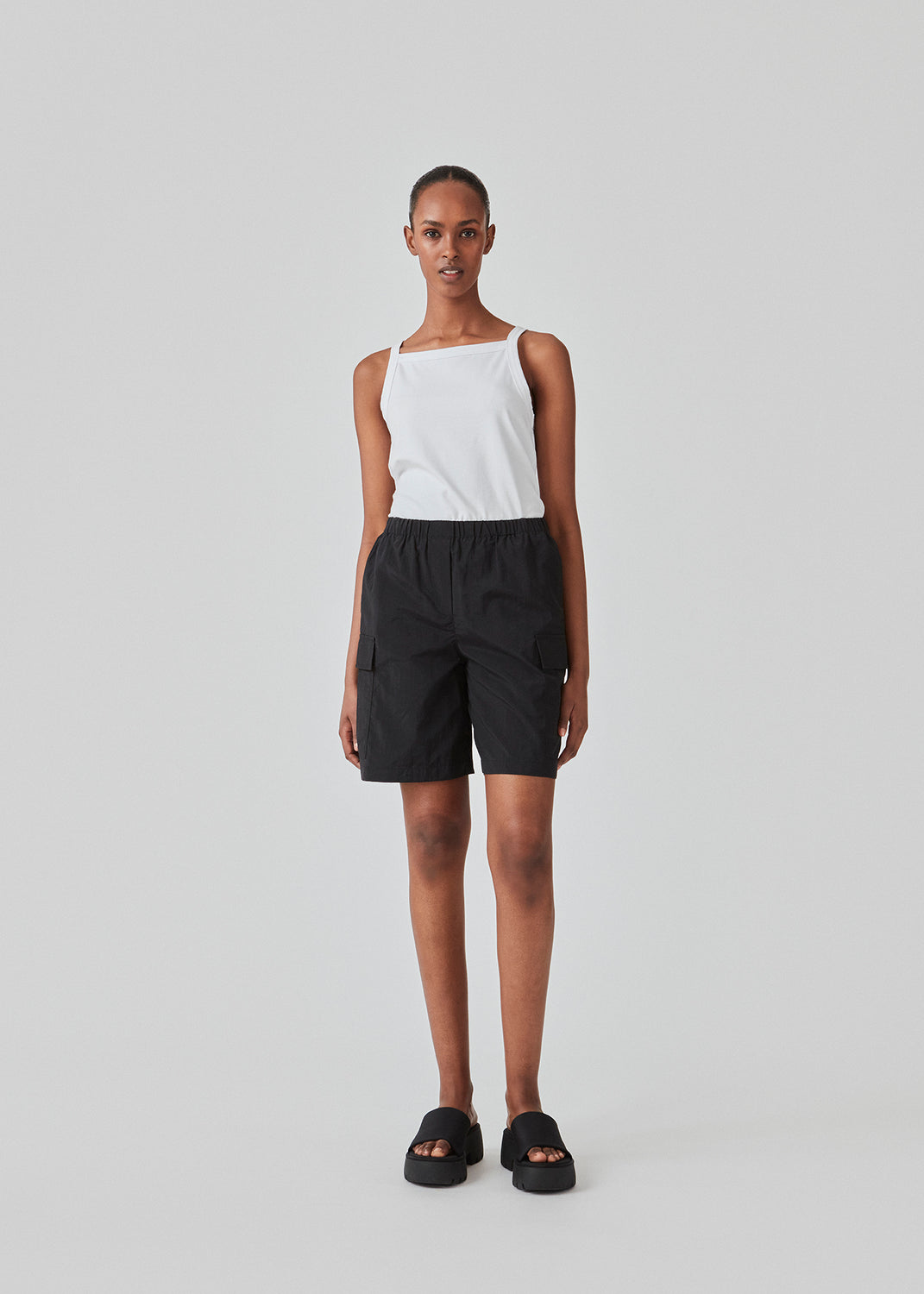 Tight fit basic white top with a high and straight neckline. DaeMD top is made from a rib-knitted organic cotton. The model is 177 cm and wears a size S/36.