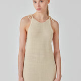 Open knit dress in beige in organic cotton. DariaMD dress has a slim fit with a long skirt, and straps that ties over the shoulder. The model is 177 cm and wears a size S/36.