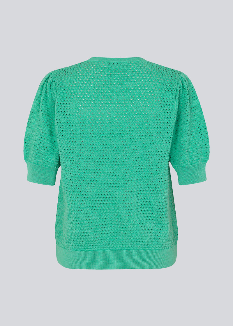DariaMD o-neck is an open-knitted jumper in green with short puff sleeves and a round neck. Ribbed trimmings at the bottom, neckline, and cuffs. The model is 177 cm and wears a size S/36.