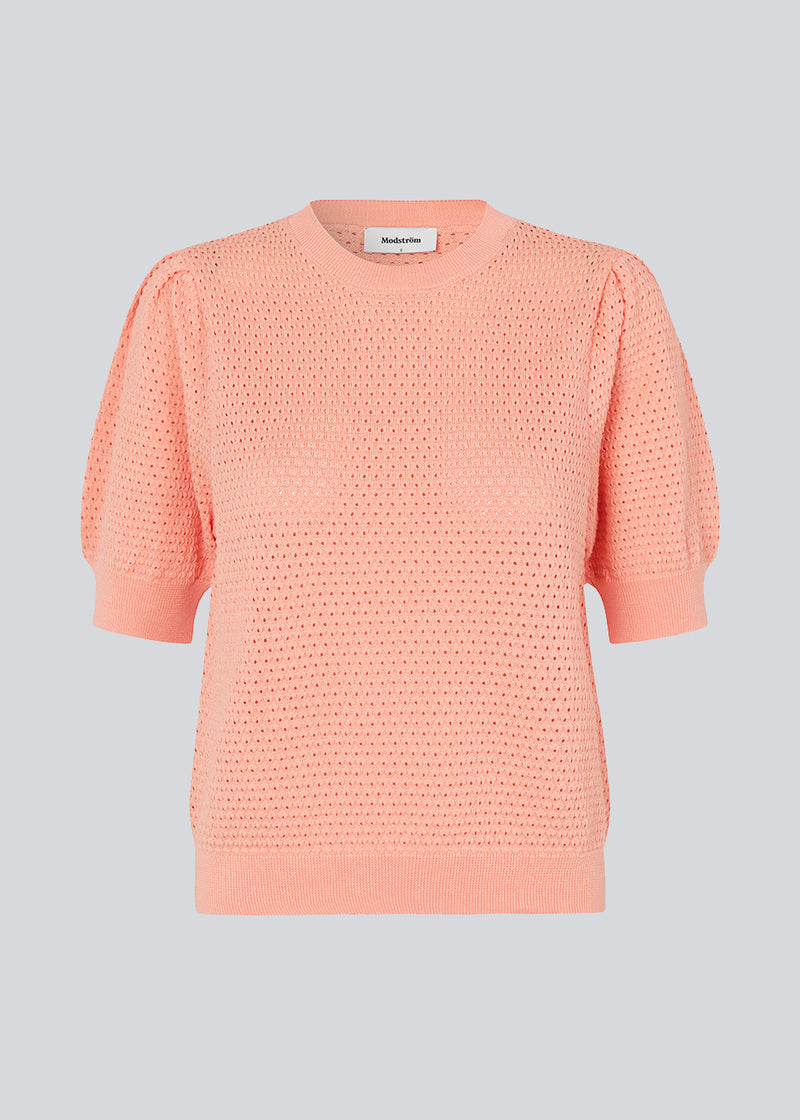 DariaMD o-neck is an open-knitted jumper in the color Peach Nectar with short puff sleeves and a round neck. Ribbed trimmings at the bottom, neckline and cuffs. The model is 177 cm and wears a size S/36.