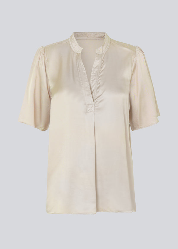 White shirt in a satin quality with a relaxed shape. DevanMD top has a v-neckline with open collar and short puff sleeves. 