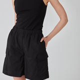 Cargo shorts in black in nylon with wide legs. DilaraMD shorts have an elasticated waistband and two large patch pockets on the sides. The model is 177 cm and wears a size S/36.