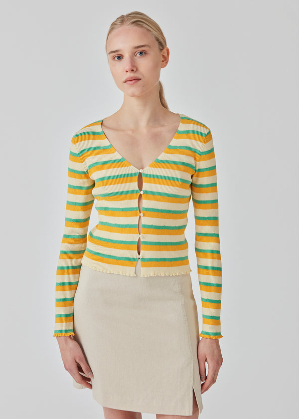 Slim fitted, slightly cropped cardigan with stripes with buttons at the front. DorisMD cardigan has a deep and round neckline, long sleeves, and lettuce hems. The model is 177 cm and wears a size S/36.