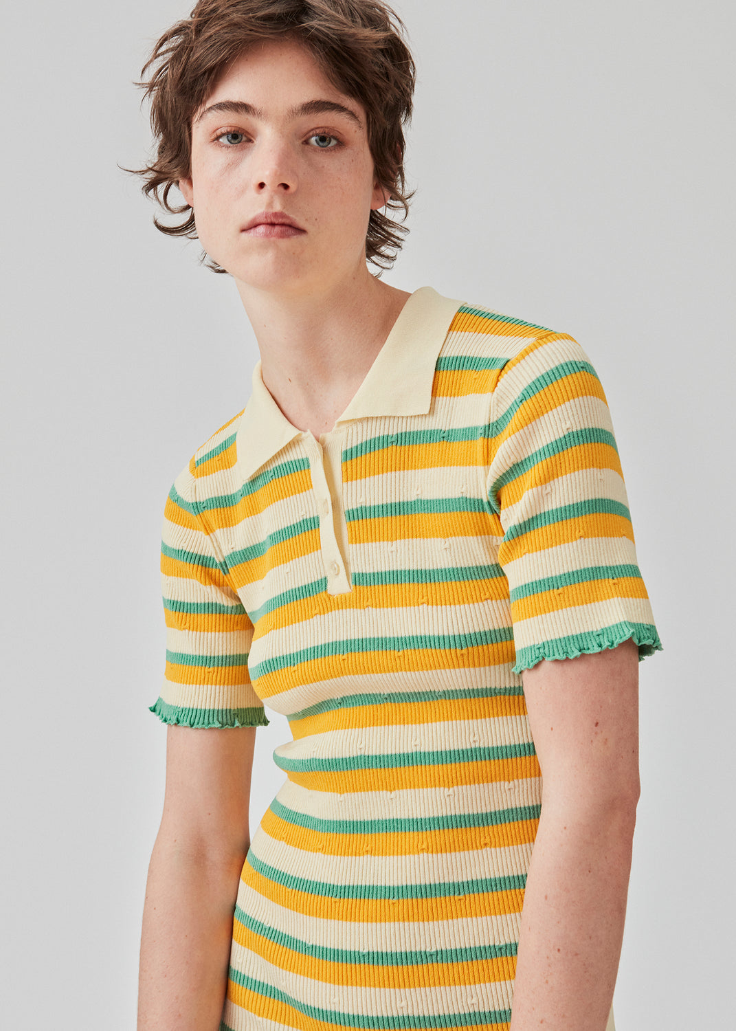  Tight fit long dress in a stretchy quality with stripes. DorisMD dress features a polo collar with buttons, short sleeves, and lettuce hems. The model is 177 cm and wears a size S/36.