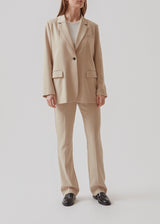 Gale blazer in Powder Sand has a classic and elegant design, fulfilled by the beautiful revers collar and a long fit. The blazer has button closure at the front and a chest pocket at the left side.  Buy Gale Pants or GaleMD shorts, in the same color that fits the Blazer. This blazer has a spacious fit. We recommend sizing down.