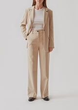 Gale pants in Powder Sand have a classic design. The pants have straight, wide legs with pressfolds, which creates an elegant look.  Buy Gale Blazer in the same color that fits the pants. These pants have a spacious fit. We recommend sizing down.