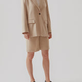 GaleMD shorts in beige have a classic design. The shorts cuts at knee-length, and have wide legs with creases for an elegant look. The model is 173 cm and wears a size S/36.  Buy Gale blazer in the same color that fits the shorts.  Material: 35% Polyester 65% Rayon  Lining: 100% Polyester