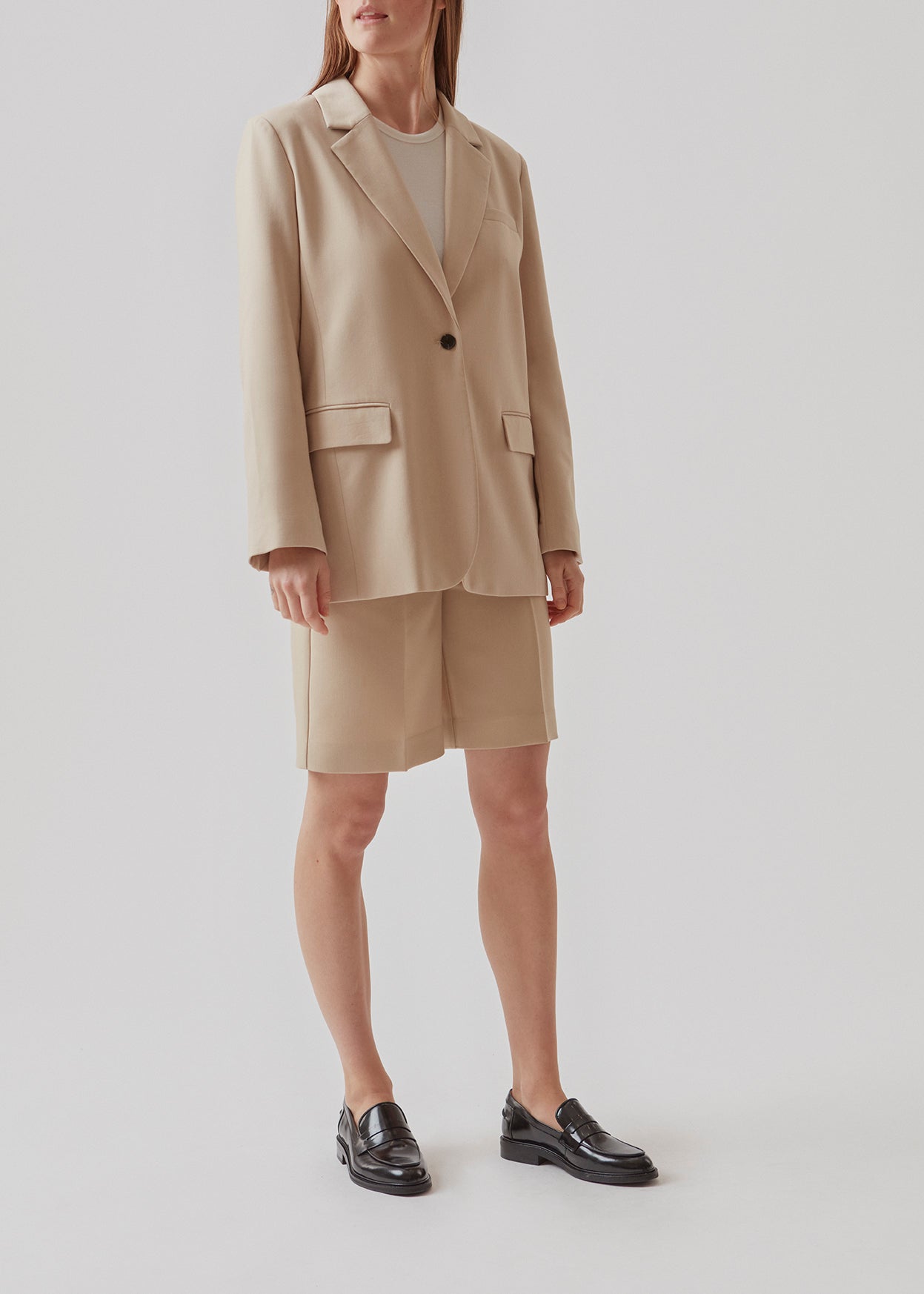GaleMD shorts in beige have a classic design. The shorts cuts at knee-length, and have wide legs with creases for an elegant look. The model is 173 cm and wears a size S/36.  Buy Gale blazer in the same color that fits the shorts.  Material: 35% Polyester 65% Rayon  Lining: 100% Polyester