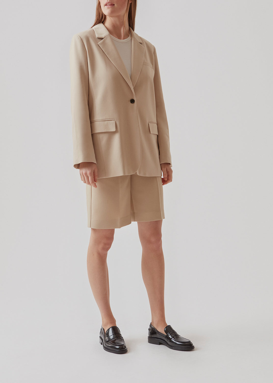 GaleMD shorts in beige have a classic design. The shorts cuts at knee-length, and have wide legs with creases for an elegant look. The model is 173 cm and wears a size S/36.  Buy Gale blazer in the same color that fits the shorts.  Material: 35% Polyester 65% Rayon  Lining: 100% Polyester