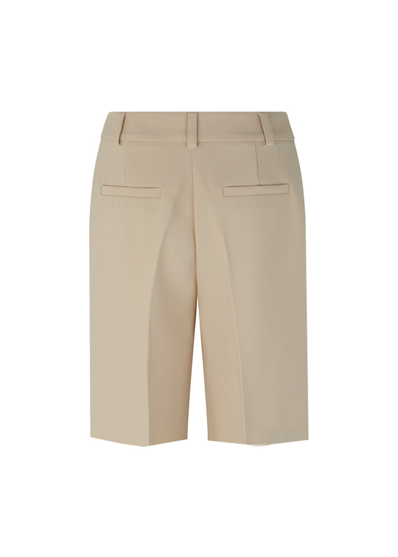 GaleMD shorts in beige have a classic design. The shorts cuts at knee-length, and have wide legs with creases for an elegant look. The model is 173 cm and wears a size S/36.  Buy Gale blazer in the same color that fits the shorts.