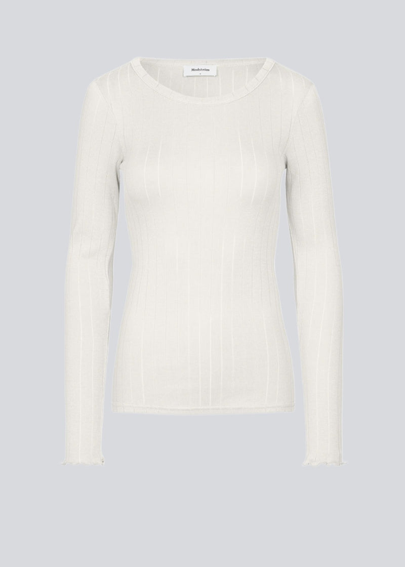 Tight fitted longsleeved t-shirt with a feminine lettuce trim on the sleeves. Issy LS t-shirt in color Off White is made from a soft jersey quality with a decorative drop needle pattern.