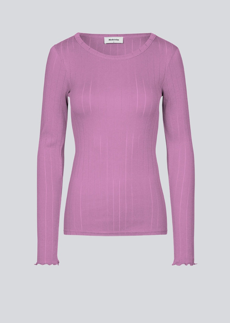 Tight-fitted long-sleeved t-shirt in the color: Pale Grape, with a feminine lettuce trim on the sleeves. Issy LS t-shirt is made from a soft jersey quality with a decorative drop needle pattern.