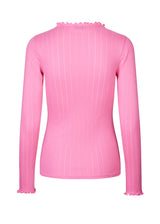 Tight fitted t-shirt in pink with a medium high neck. Issy t-neck has feminine lettuce hem on neck and sleeves. The quality is a soft jersey with a feminine pointelle pattern.