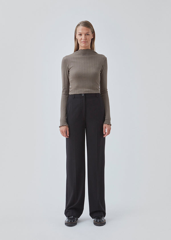 Tight fitted t-shirt in brown with a medium high neck. Issy t-neck has feminine lettuce hem on neck and sleeves. The quality is a soft jersey with a feminine pointelle pattern.