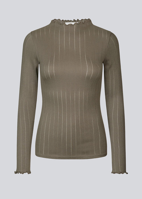 Tight fitted t-shirt in brown with a medium high neck. Issy t-neck has feminine lettuce hem on neck and sleeves. The quality is a soft jersey with a feminine pointelle pattern.