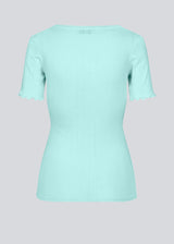 Tight fitted t-shirt with feminine lettuce hem at the sleeves. Issy t-shirt in the coloe Topaz comes in a soft drop needle jersey. The model is 174 cm and wears a size S/36