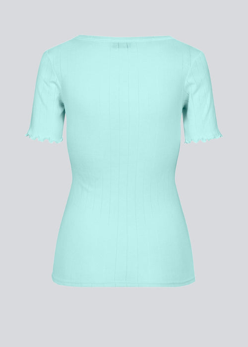 Tight fitted t-shirt with feminine lettuce hem at the sleeves. Issy t-shirt in the coloe Topaz comes in a soft drop needle jersey. The model is 174 cm and wears a size S/36