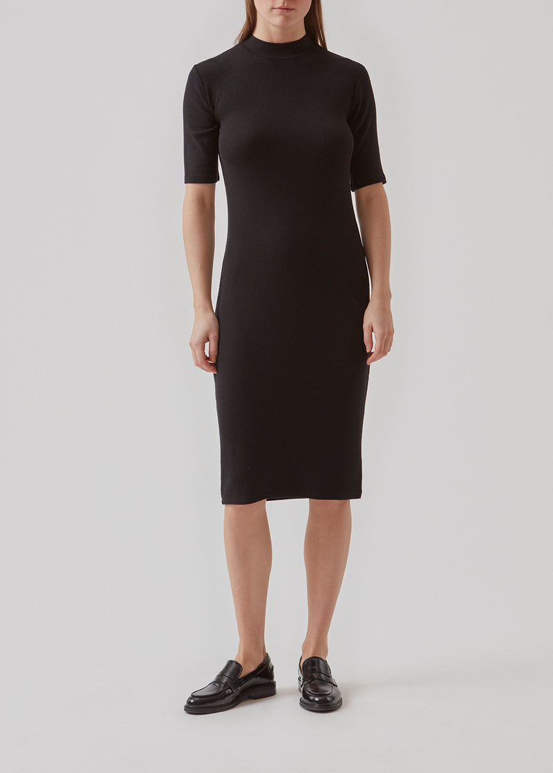 Short-sleeved dress with a high neck. Krown t-shirt dress is in a nice rib quality and has a tight fit. Krown t-shirt dress in Black is a must-have basic style in your waredrobe and a responsible choice.