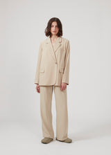 Beige blazer with an oversize fit and an asymmetrical look. PerryMD blazer is designed in a light material, which is easy to style with matching pants or over a dress on a summer evening.  Buy matching pants to complete the look: PerryMD pants.