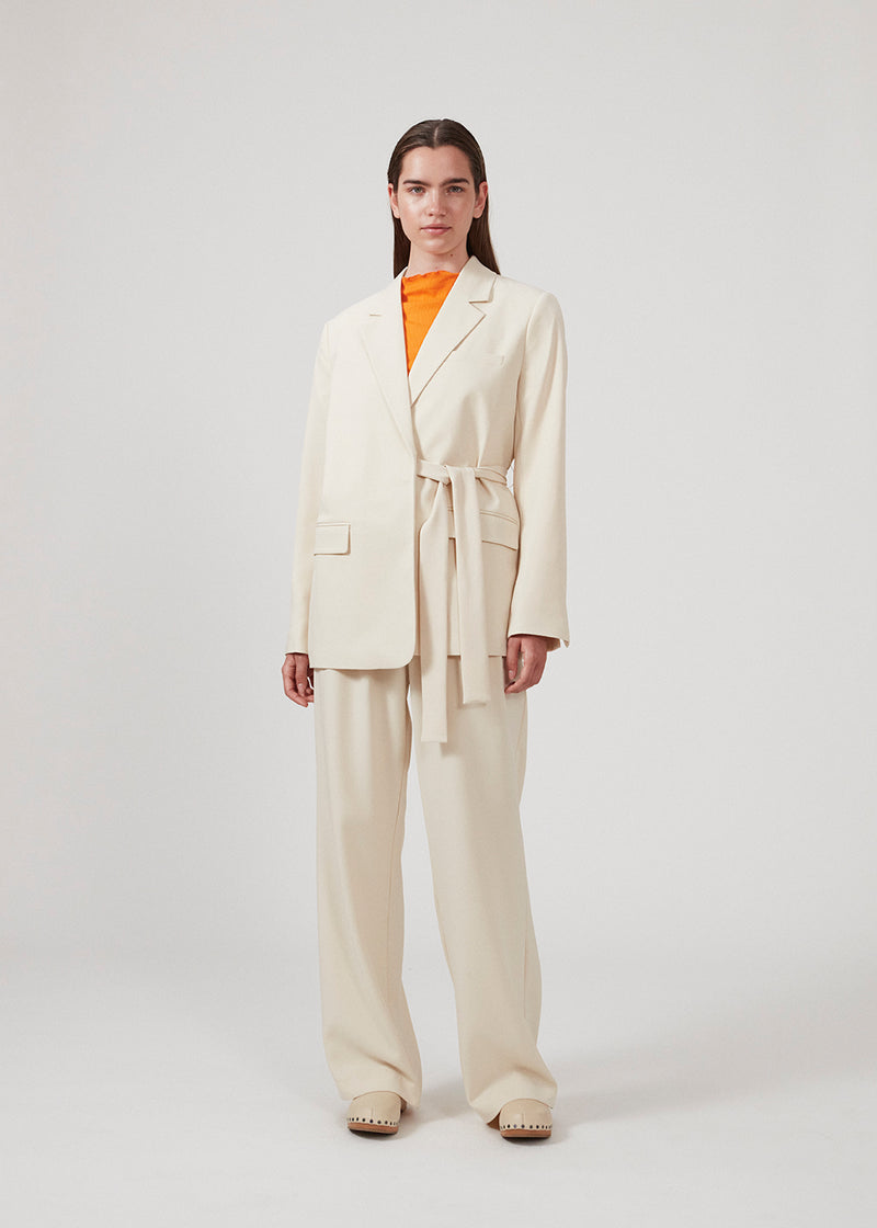 CayaMD blazer is designed for a relaxed fit with classic details with a twist from the tie-belt at the waist. Made from recycled materials. The model is 177 cm and wears a size S/36.  Style with the matching pants: CayaMD pants.