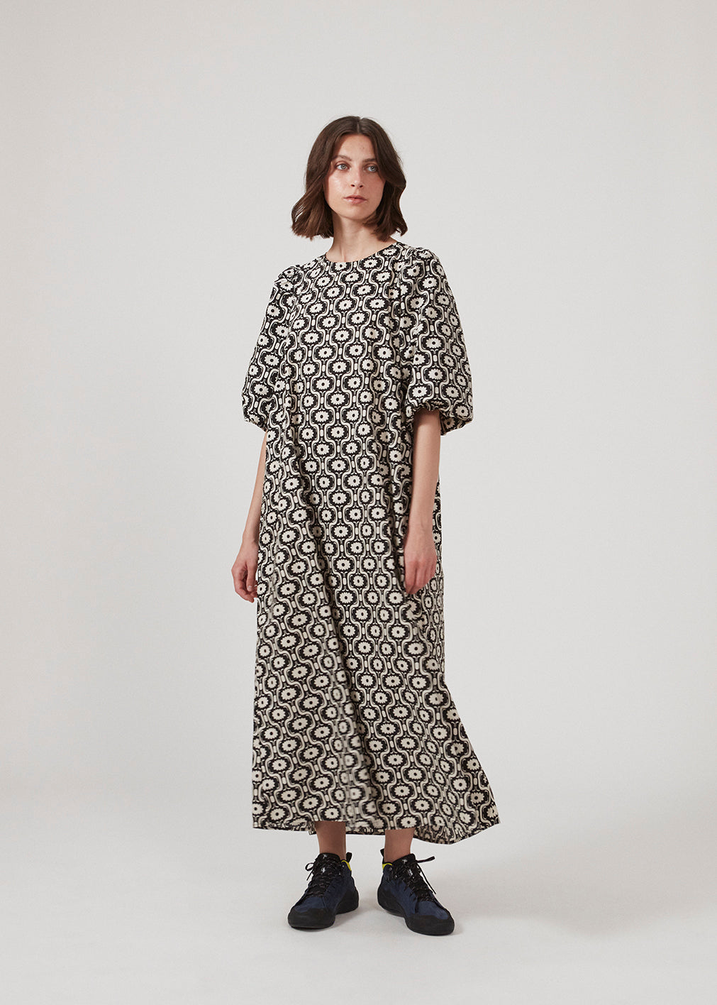 Long dress with a wide skirt and voluminous puff sleeves. CoraMD print dress has a round neck with a cut out and bow in the back. Made from organic cotton.  The model is 174 cm and wears a size S/36.