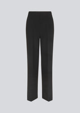 Classic pants with pressfolds and straight legs. Nelli pants are closes by an hidden zipper at the side with an elastic waistband for a more comfortable fit. The model is 173 cm and wears a size S/36