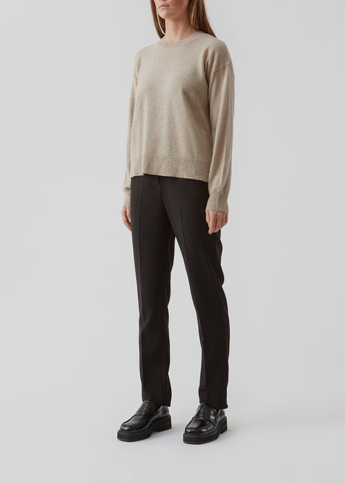 Cashmere Noris o-neck in beige is, with its classic design and luxurious cashmere quality, a musthave for every wardrobe. Noris o-neck has a round neck and slits at the side. The model is 173 cm and wears a size S/36.
