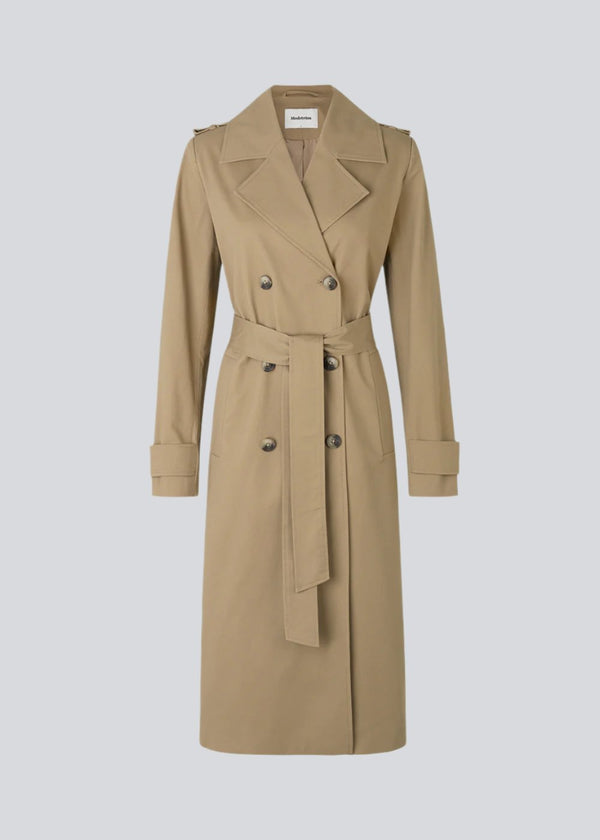 Classic trenchcoat in a rich cotton quality. Oak jacket is double-breasted, with revers, and a slit at the back. The wide belt and cuff adds extra details to the recognizable silhouette. The model is 173 cm and wears a size S/36