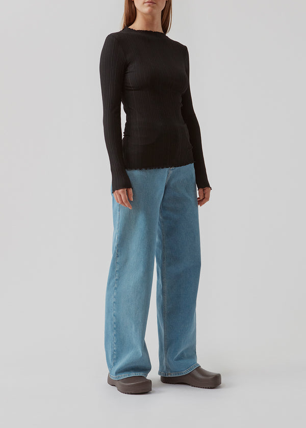 Tight-fitted, long sleeved t-shirt with ruffled trimmings on sleeves, at the neck and bottom. Oasis t-neck in Black fits perfectly as a basic style in the wardrobe.