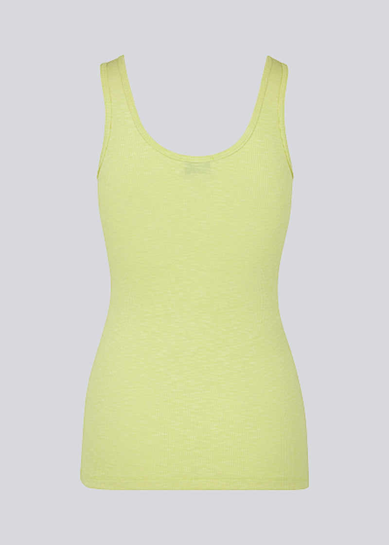 Olla top in yellow is a simple tanktop in a soft rib material. The top has a tight and figure-hugging silhouette which has a soft feel under a knitted sweater or shirt. The model is 173 cm and wears a size S/36.