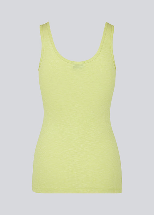 Olla top in yellow is a simple tanktop in a soft rib material. The top has a tight and figure-hugging silhouette which has a soft feel under a knitted sweater or shirt. The model is 173 cm and wears a size S/36.