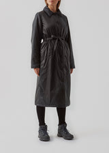 Sporty coat with collar, buttons and waist belt. Oma jacket is a cool coat in nylon in voluminous but feminine silhouette. The light padding of the coat is 100% recycled polyester. The model is 173 cm and wears a size S/36